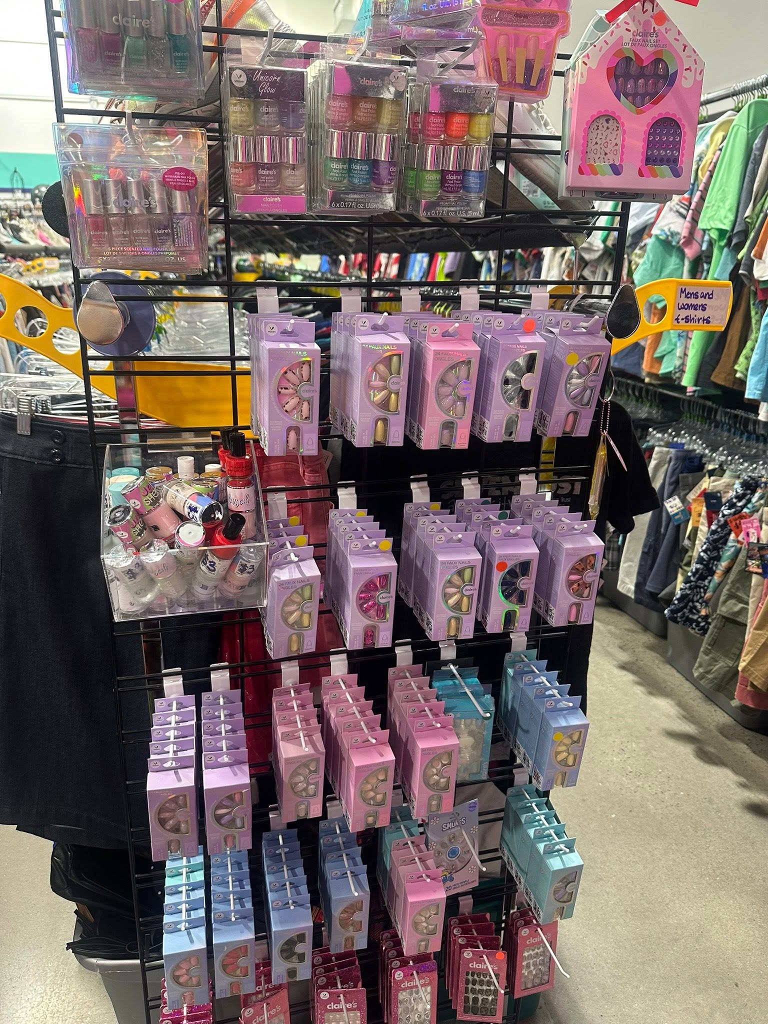 Display rack of nail polish sets and press-on nails near the clothing racks