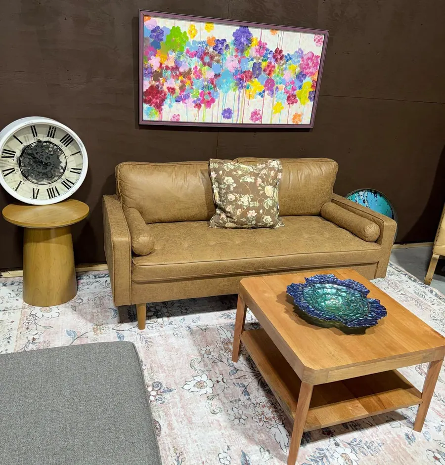 Leather sofa, wood coffee table and framed art in a furniture display