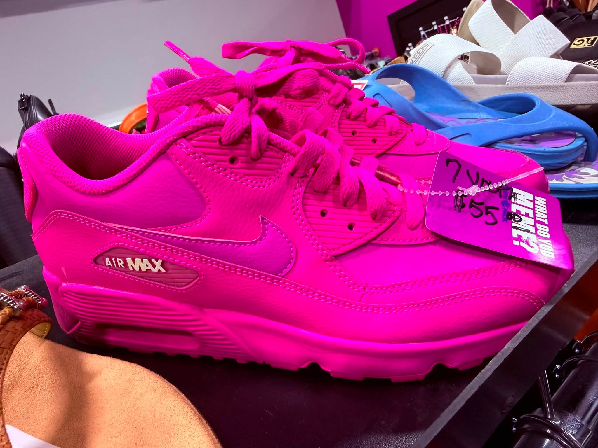 Close-up of a bright pink Nike Air Max sneaker on a shoe display shelf
