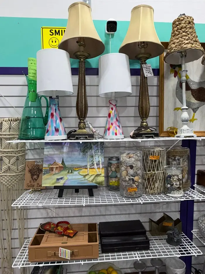 Table lamps and jars of shells displayed on wire shelving