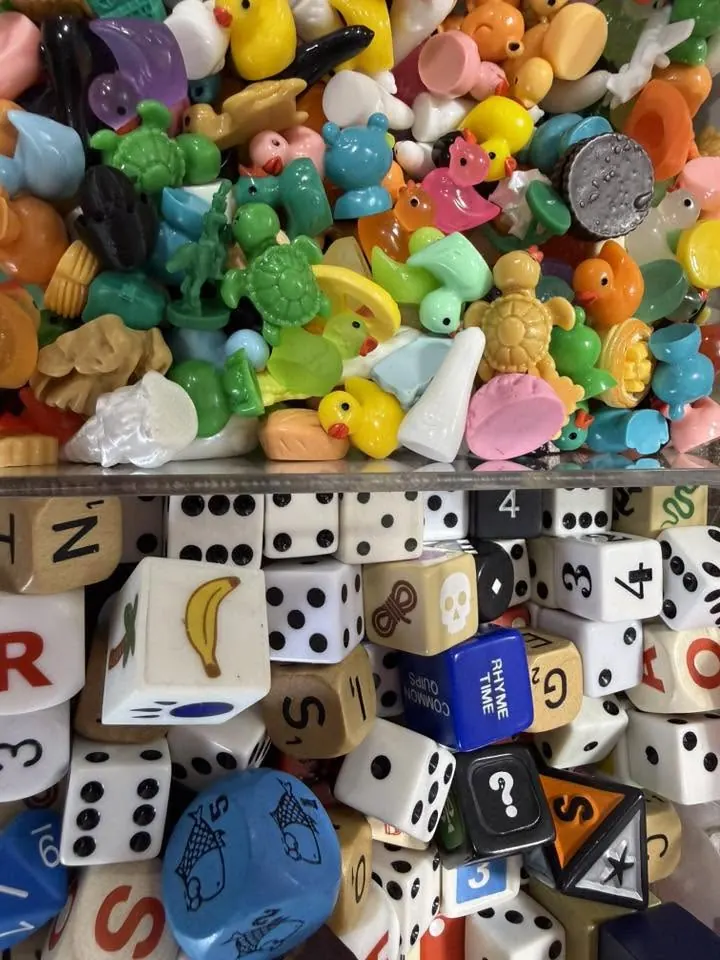 Small toys, dice and game pieces in bins