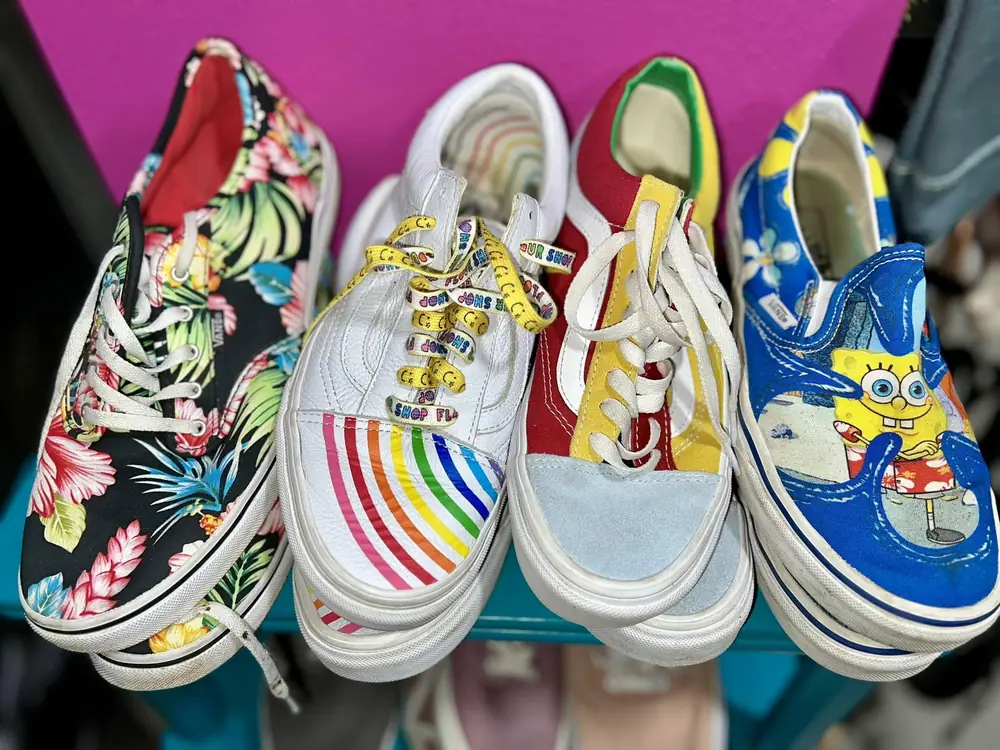 Colorful patterned sneakers lined up against a pink wall